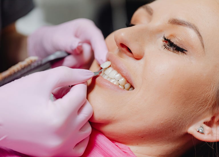 Dentist matching a tooth shade against a shade guide